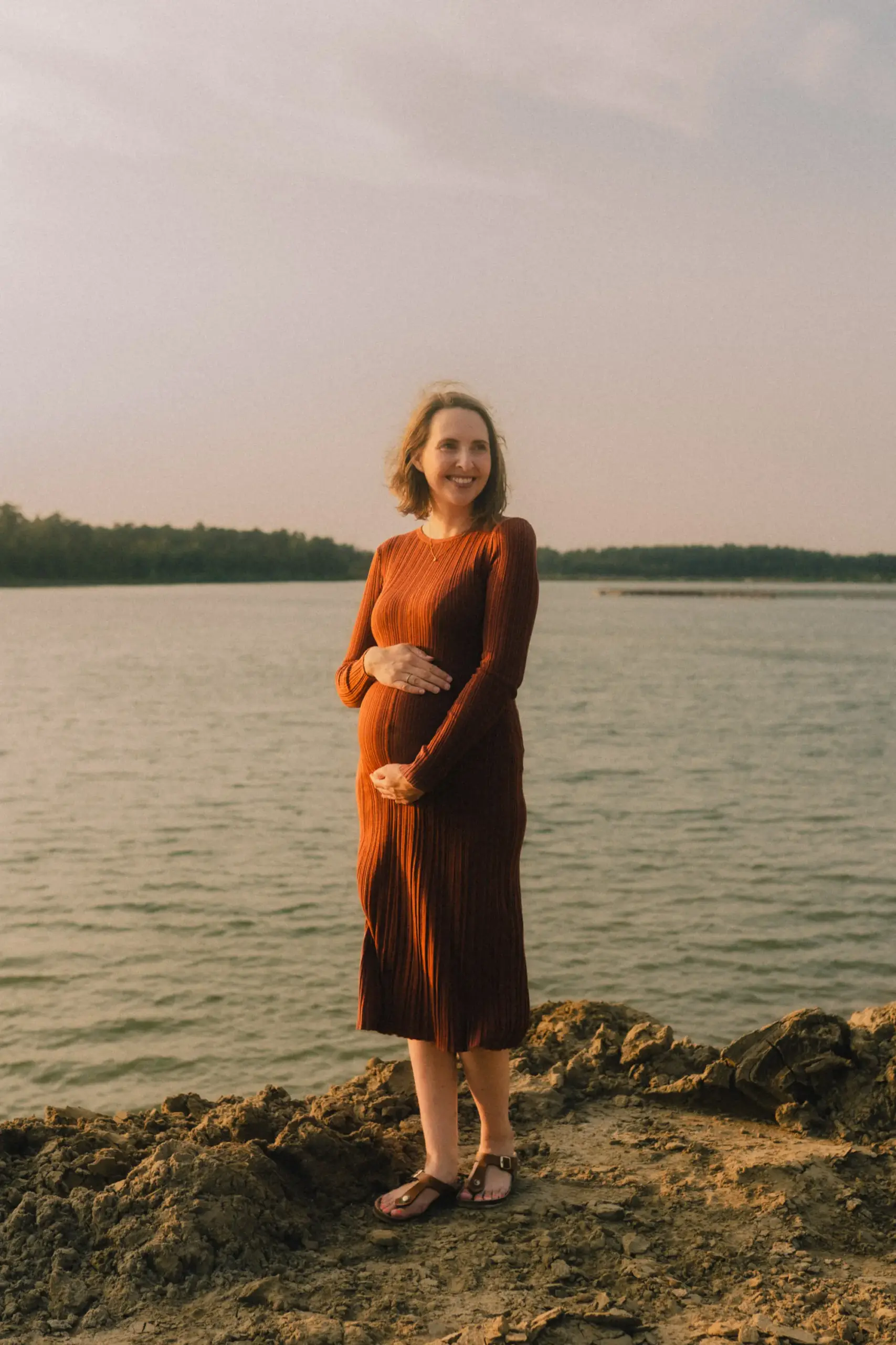 Schwangere Frau mit Rostroten Kleid am See