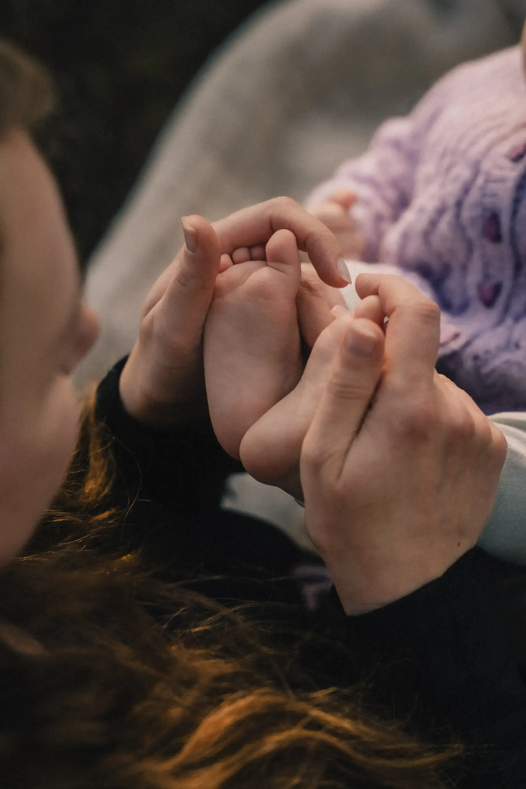 Babyfüße in den Händen der Mutter