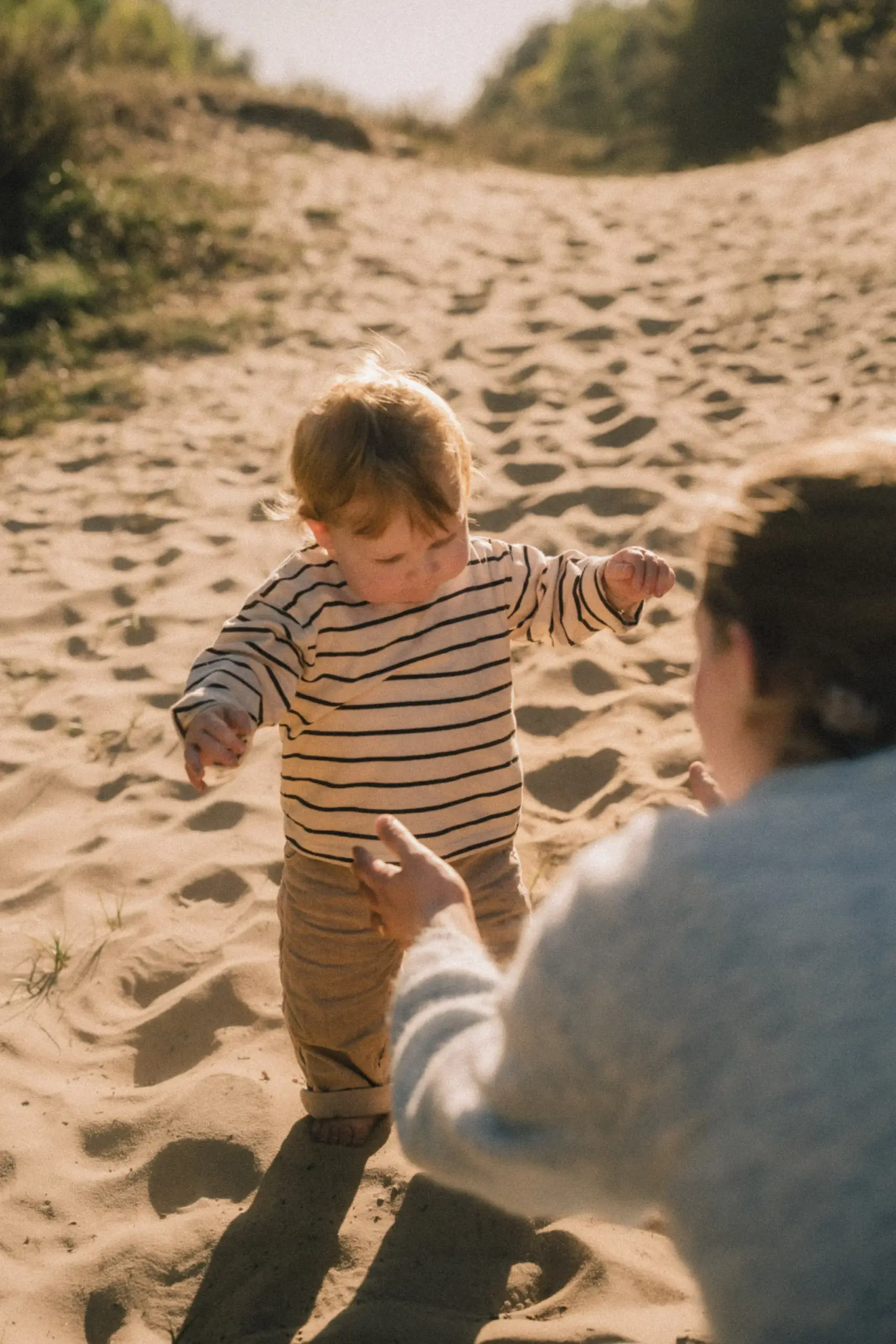 Baby macht seine ersten Schritte im Sand