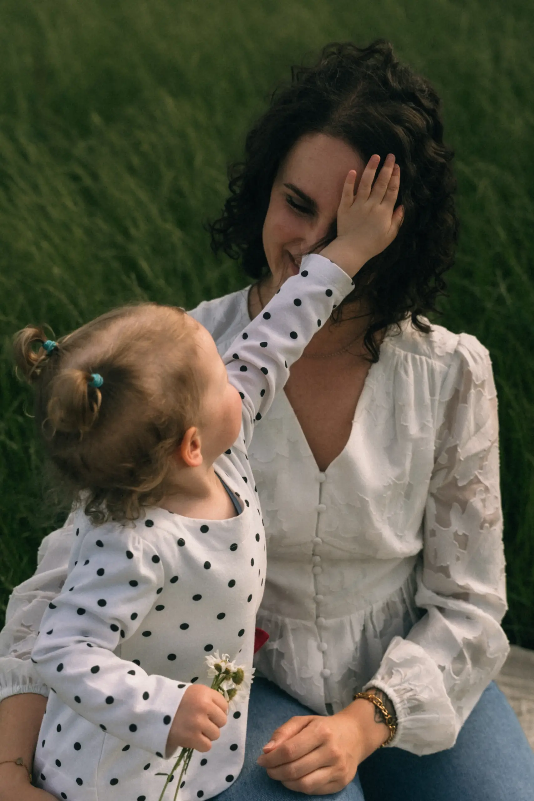 Kleinkind streichelt Mama durchs Gesicht